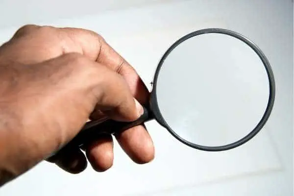 person using a magnifying glass to focus on something