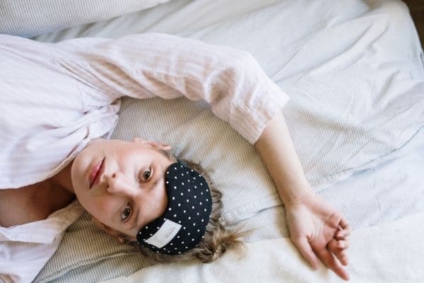 woman anxiously lying awake in bed