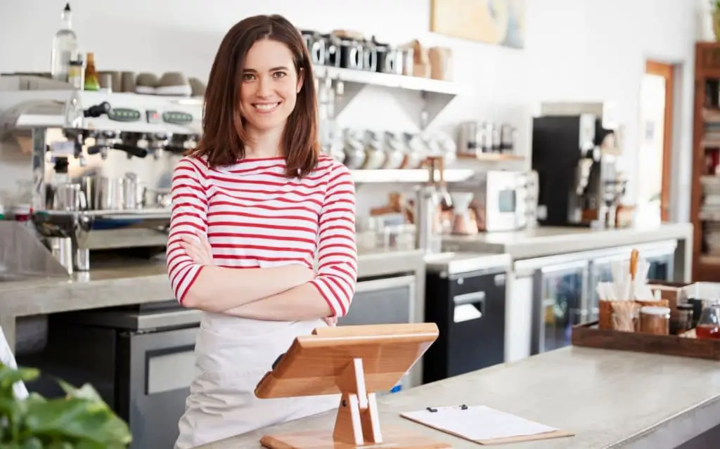 a small cafe owner behind the counter of her business