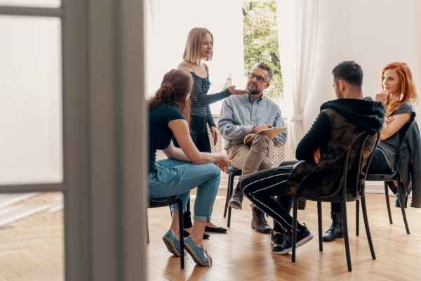 Five people sitting in a circle for group support