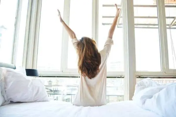woman refreshed and stretching in the morning after a good sleep