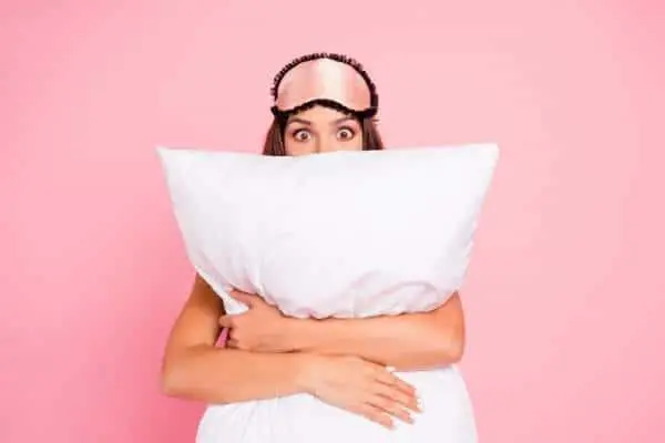 woman getting ready for bed holding a pillow