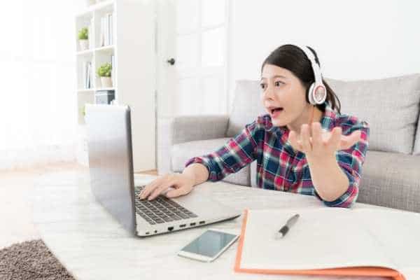 a woman in a meeting wearing headphones talking to her computer screen