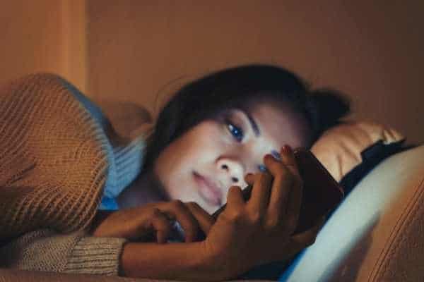 woman looking at phone, cannot fall asleep