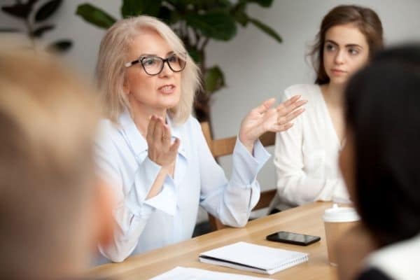 A woman talking to a group of people 