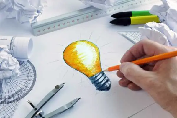 a hand drawing a lightbulb
