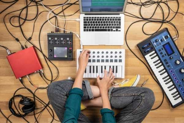 person sitting on the floor surrounded by music recording equipment