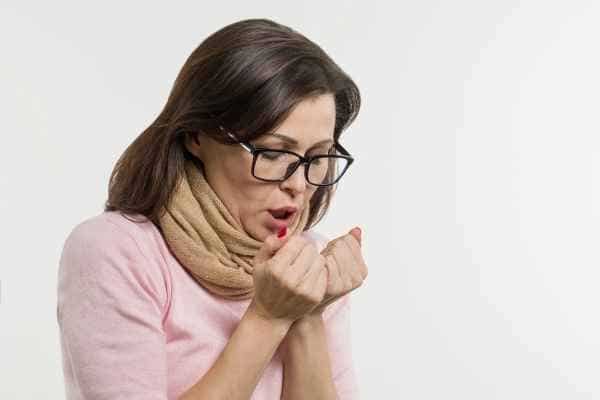 woman warming her cold hands with her breath