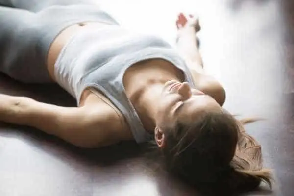 a woman lying down and doing a NSDR Yoga Nidra protocol