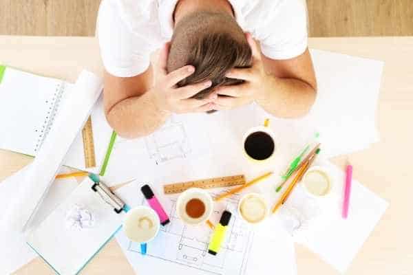 stressed out student with several empty cups of coffee