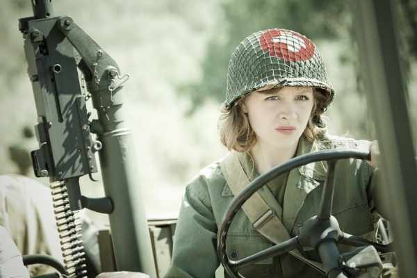 woman in army fatigues driving a jeep