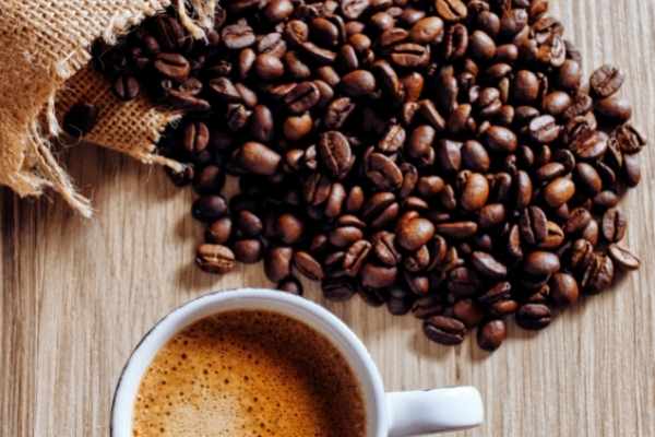 coffee beans next to a cup of coffee