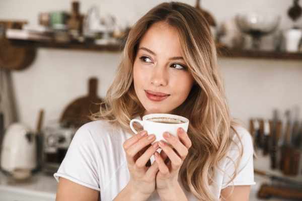 woman holding a cup of coffee in a shop