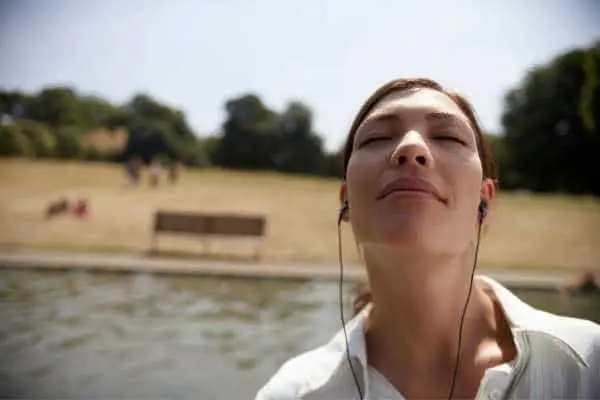 woman at the beach looking relaxed and wearing headphones 