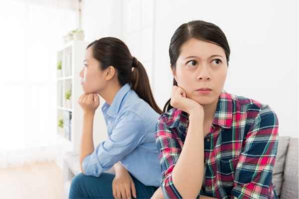 two friends upset, giving each other the silent treatment and looking away from each other