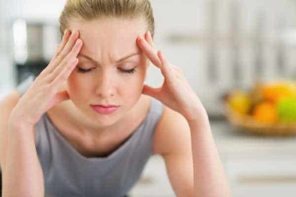 woman with headache holding her temples