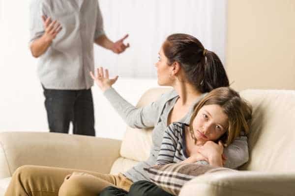 a child looking tired as her parents fight