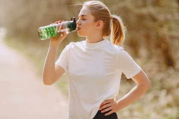 woman drinking from a water bottle