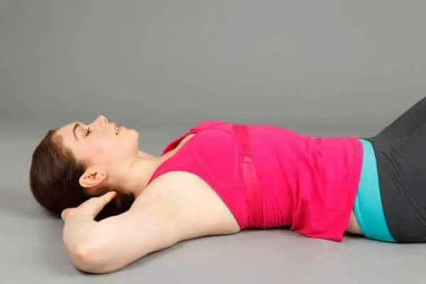 woman lying down with her head resting in her interlaced fingers