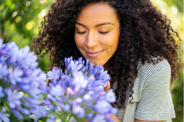 woman smelling purple flowers